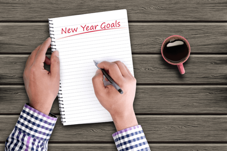 man writing down new years goals